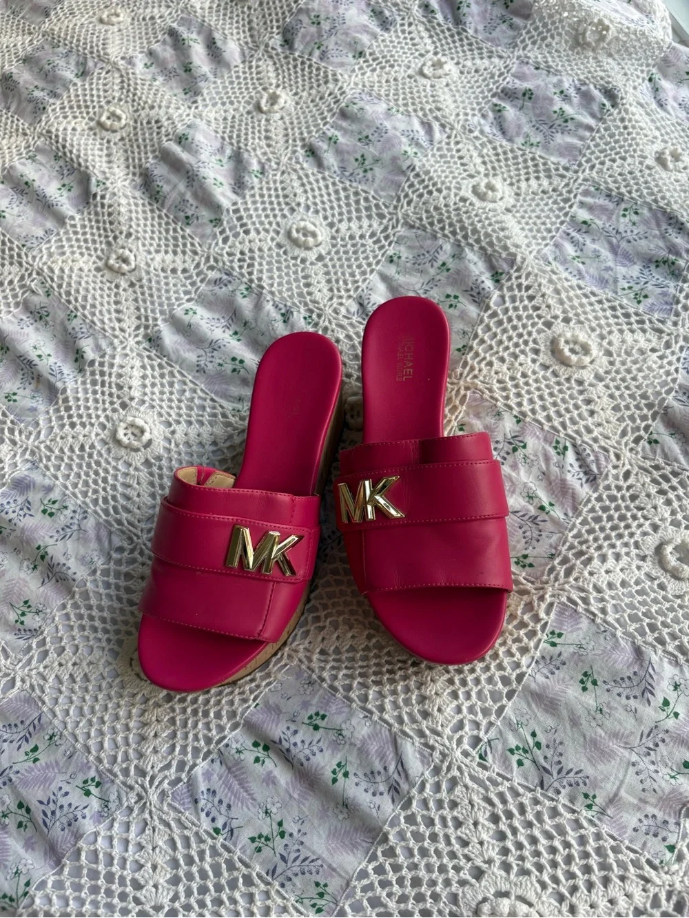 Michael Kors bright pink platform slide sandals with a cork wedge.